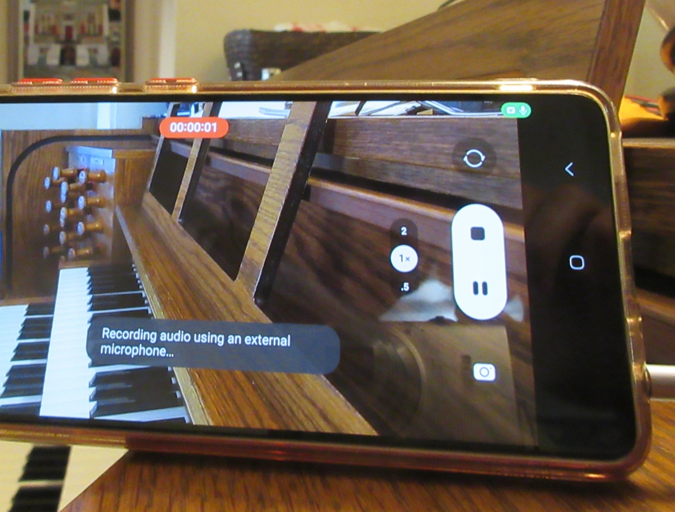 A phone with a video app open, pointed at an organ console